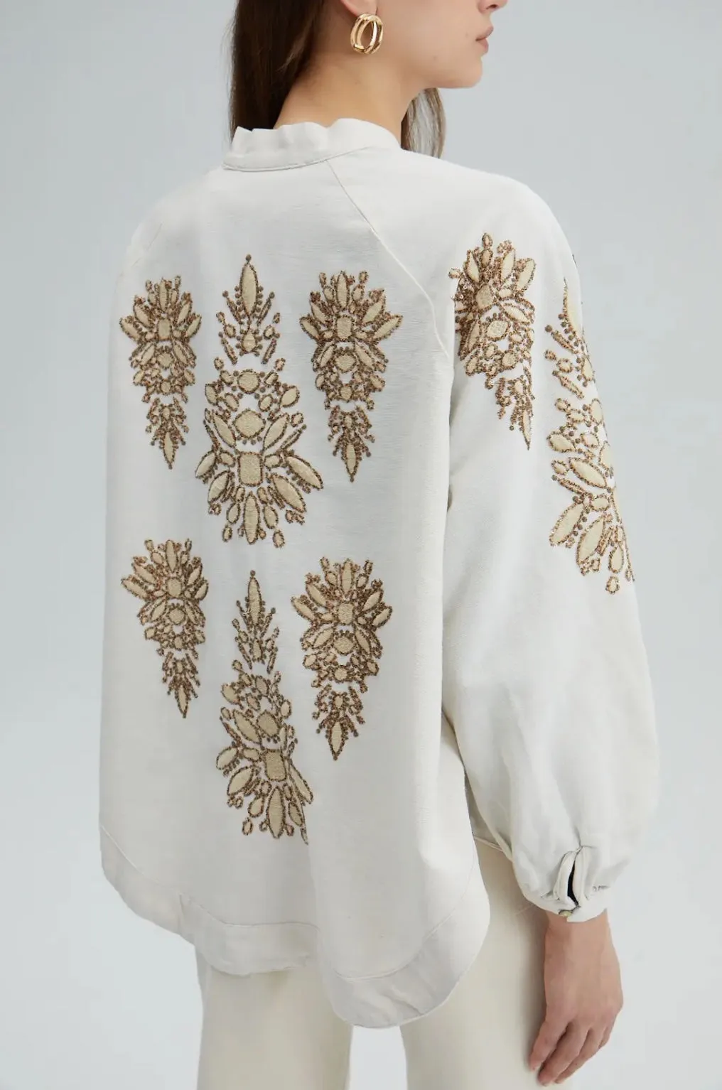 Off-white kimono jacket with shiny embroidery in earthy browns.